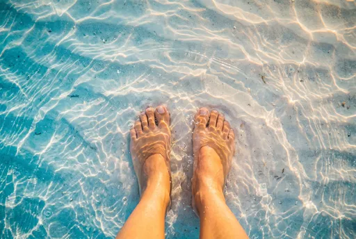 Bare Feet in Shallow Turquoise Water