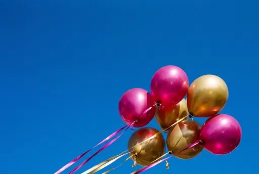 Magenta and Gold Balloons in Blue Sky