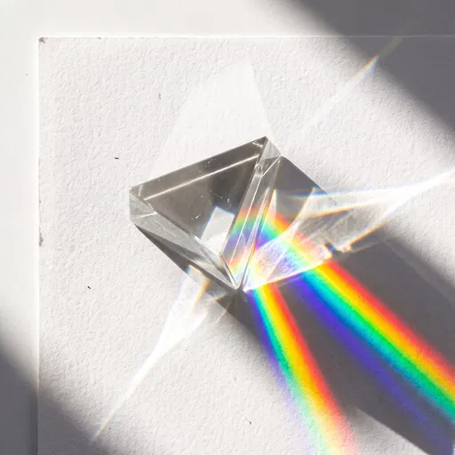 Glass Prism Refracting Rainbow on Paper