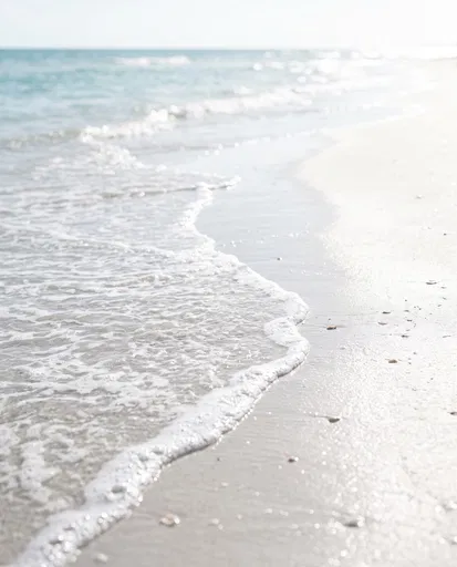 Gentle Ocean Foam on White Sand Beach