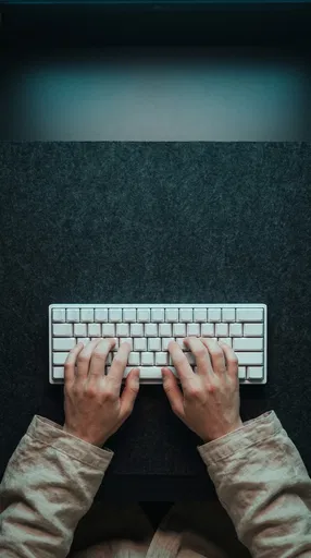 Overhead Hands Typing on Blank White Keyboard