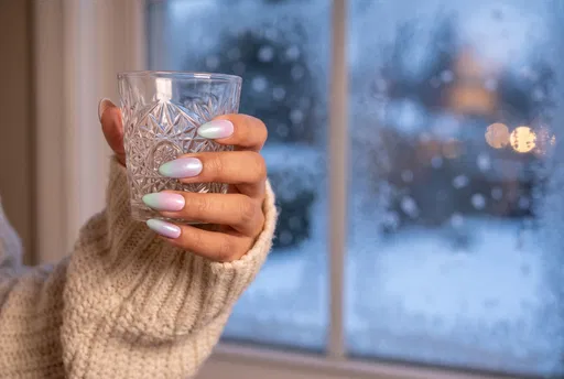 Hand With Pastel Nails Holding Crystal Glass