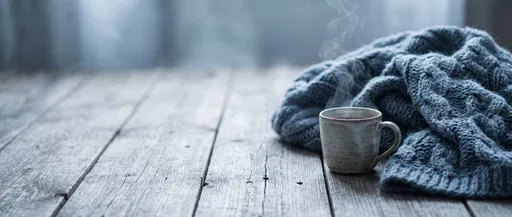 Steaming Mug and Knit Blanket on Wood