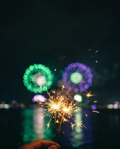 Handheld Gold Sparklers With Defocused Night Fireworks