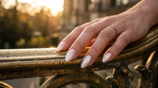 Hand With Pearl Nails on Brass Railing