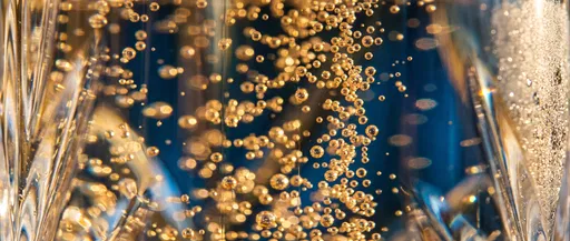 Macro Golden Champagne Bubbles in Crystal Glass