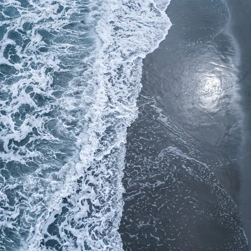 Aerial View of Ocean Surf on Wet Sand