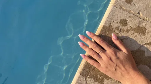 Hand with Pink French Nails by Pool