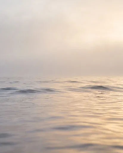 Calm Misty Ocean Horizon at Sunset