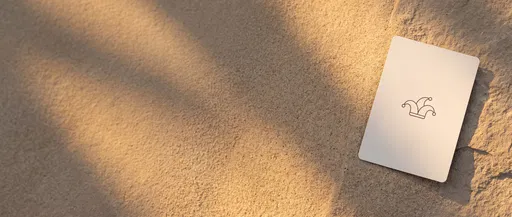 Minimalist Joker Card on Sunlit Sand