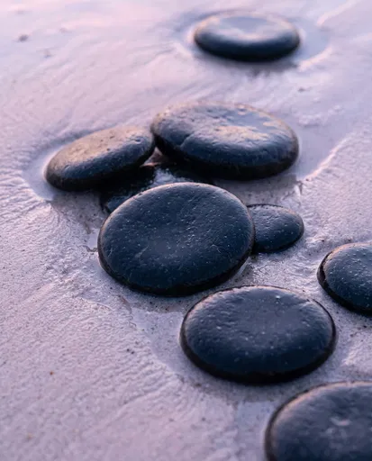 Round Black Basalt Stones on Wet Sand