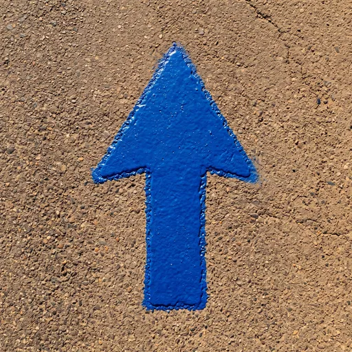 Blue Painted Arrow on Rough Pavement