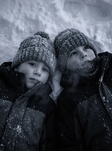 Two Children Lying in Fresh Snow