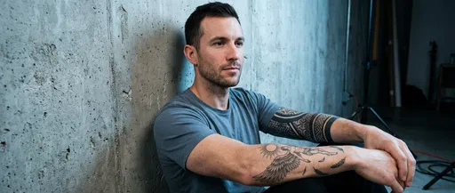 Man With Forearm Tattoos Near Wall