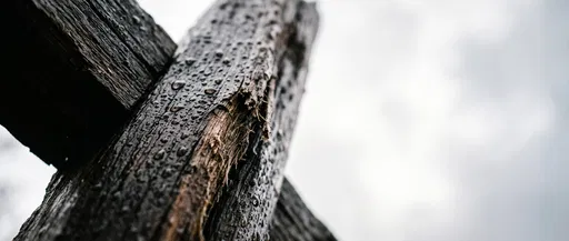 Wet Wooden Cross Against Overcast Sky