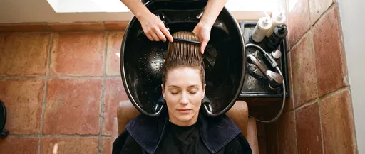 Woman Getting Hair Combed at Salon Basin