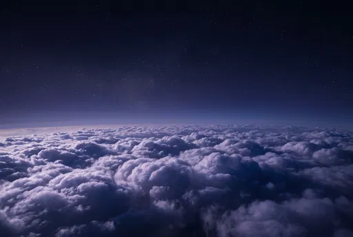 Starry Night Sky Above Lit Clouds