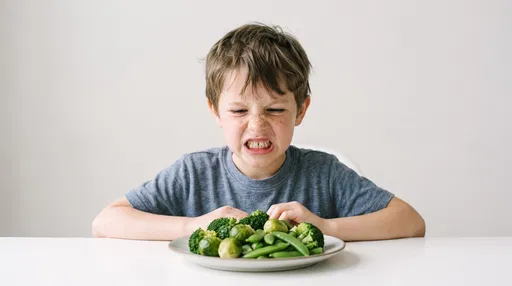 Boy Grimacing at Plate of Green Vegetables