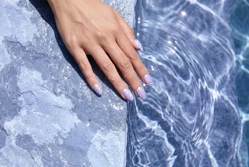 Hand With Lilac Seashell Nails by Pool