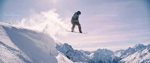 Snowboarder Jumping Off Snowy Mountain Cornice