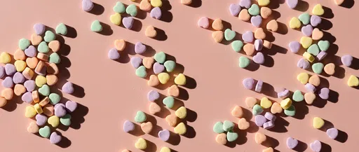 Pastel Candy Hearts Flat Lay on Pink