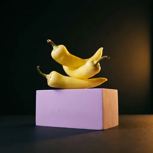 Yellow Peppers Balanced on Lavender Block