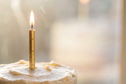 Single Gold Candle on Vanilla Cake