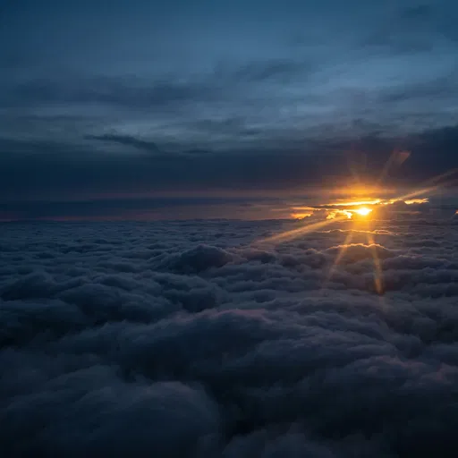 Twilight Sun Flare Above Dark Clouds