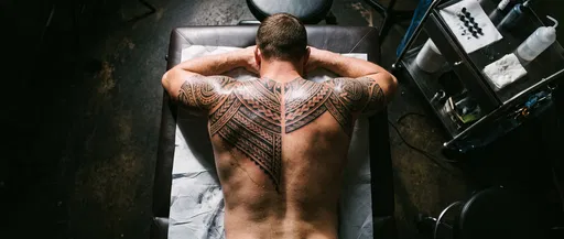 Man With Fresh Polynesian Back Tattoo