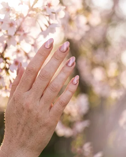 Freckled Hand With Pink Shimmer Almond Nails
