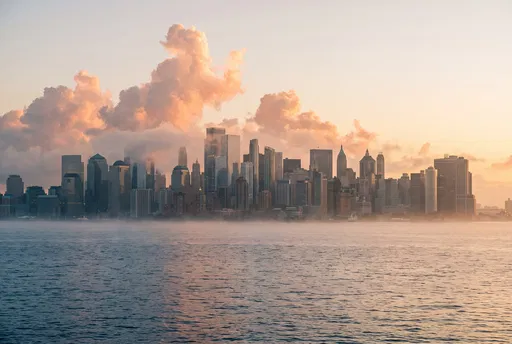 Misty Sunrise Over Distant City Skyline