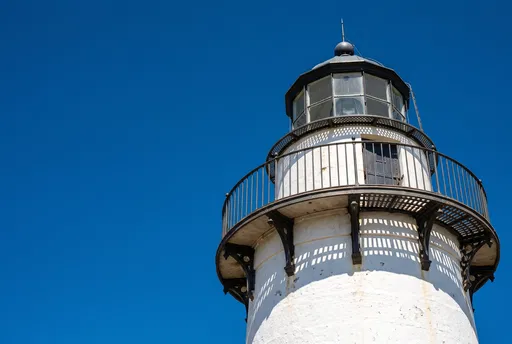 White Lighthouse Tower Against Blue Sky