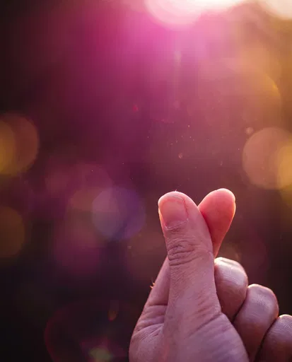 Backlit Hand Making Finger Heart Sign