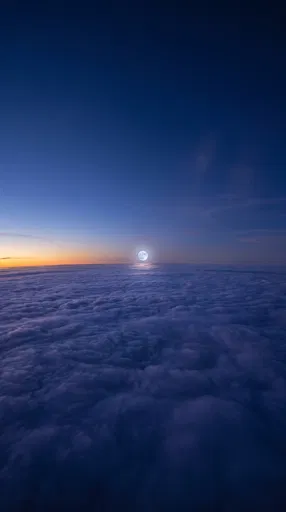 Full Moon Rising Above Twilight Clouds