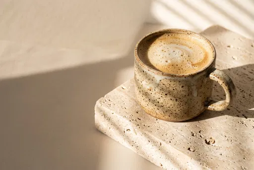 Speckled Mug of Cappuccino on Travertine