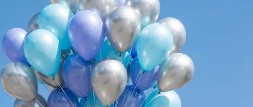 Blue and Silver Balloons Against Sky