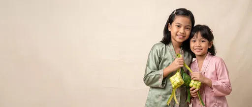 Young Sisters Holding Ketupat for Eid