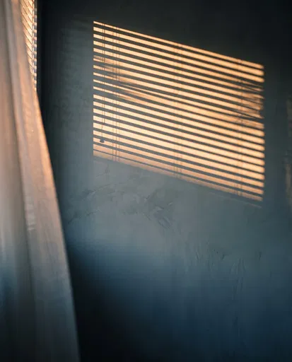 Golden Sunlight Shadows on Slate Blue Wall