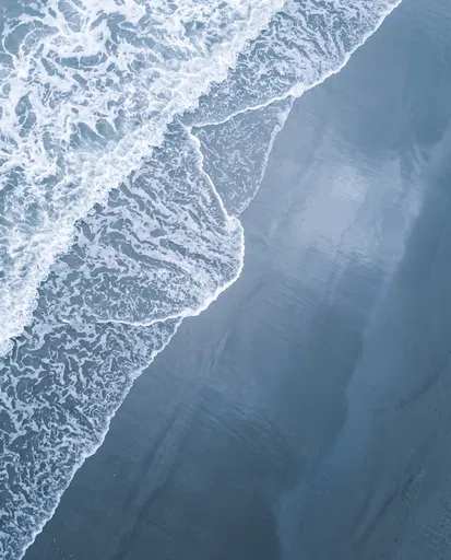 Top-Down View of Ocean Surf on Sand