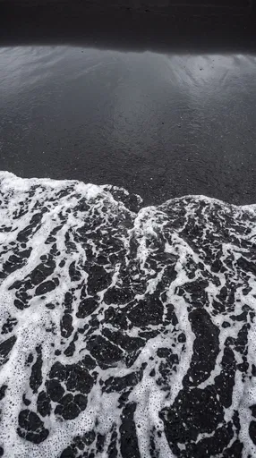 White Ocean Foam on Black Sand