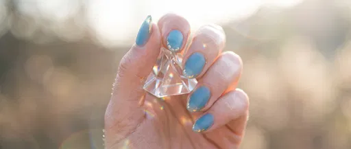 Hand Holding Prism With Blue Nails