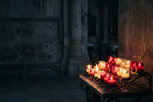 Glowing Votive Candles in Dark Stone Church