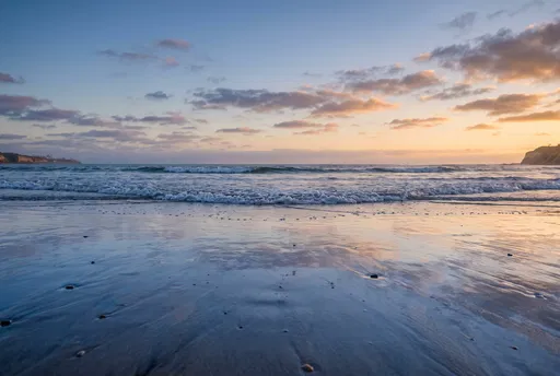 Golden Hour Reflections on Wet Beach Sand