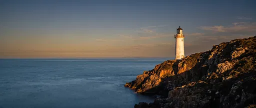 Lighthouse on Rocky Headland at Golden Hour