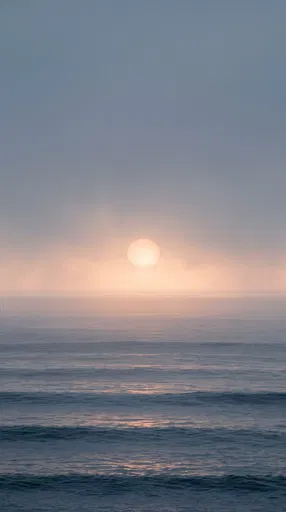 Misty Sunrise Over Calm Ocean Swells
