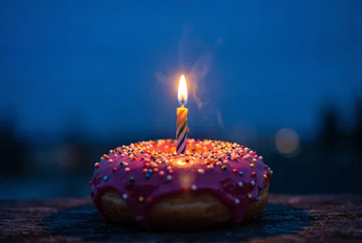 Birthday Doughnut With Lit Candle At Dusk