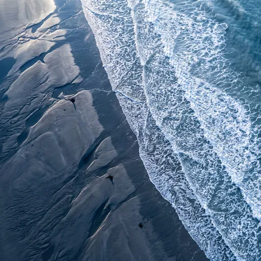 Aerial View of Waves on Dark Sand
