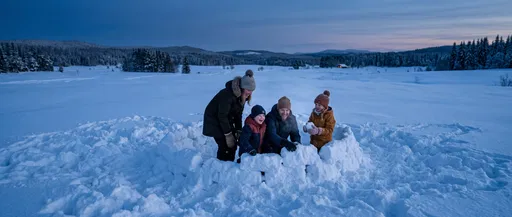 Family Building Snow Fort at Dusk