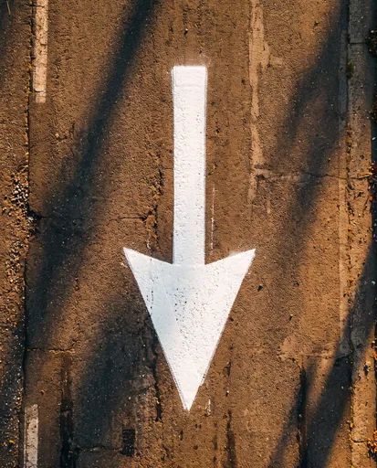 White Downward Arrow Painted on Asphalt Road