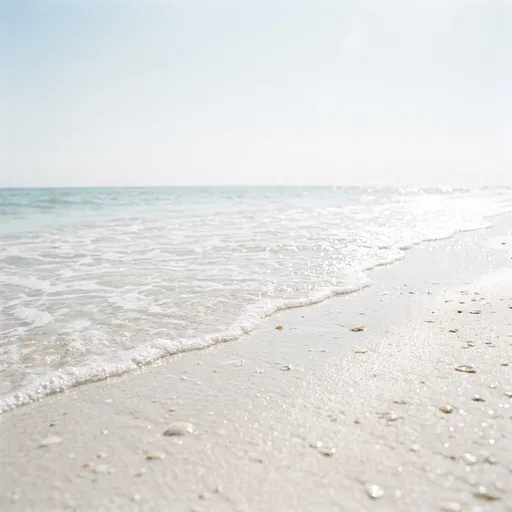 Gentle Ocean Foam on White Sand Beach